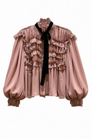 Blusa manga larga abombachada rosa palo con olanes frontales y corbatín negro-1